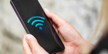 close-up-phone-hands-with-wifi-symbol_23-2148295840