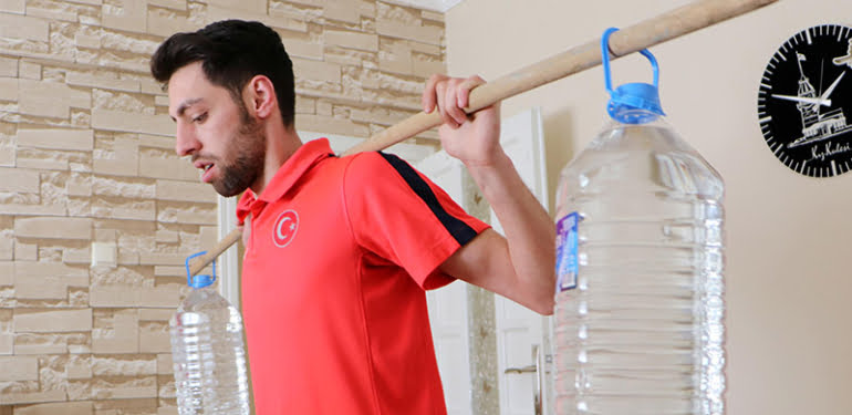 Evde, sehpa ve su bidonları ile olimpiyata hazırlanıyor