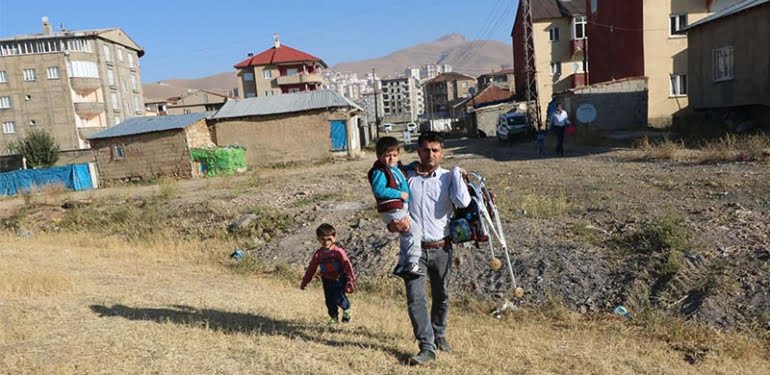 Engelli oğlunun okuması için her gün kucağında taşıyor