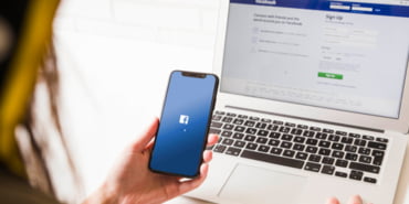woman-looking-mobile-phone-with-facebook-application-homepage_23-2147844539